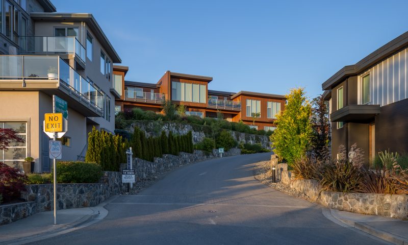 A hill leading up to buildings with a no exit sign in the left corner in the district of Saanich